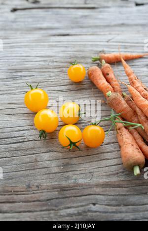 raw organic cherry tomatoes and little carrots Stock Photo