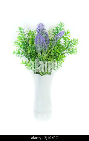 Bouquet of artificial lavender flowers with greenery in a vase in very perry color on a white background. Stock Photo
