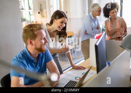 Group of software engineers working developing applications together in corporate office Stock Photo