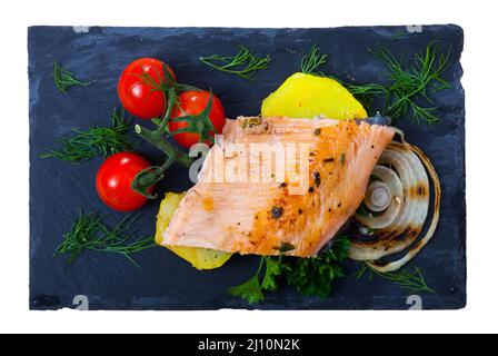 Top view of baked trout fillet with potatoes on black board Stock Photo