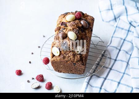Easter cake with chocolate eggs and raspberry on a gray background. Top view. Stock Photo