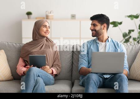 Middle Eastern Couple Using Laptop And Tablet Computers At Home Stock Photo