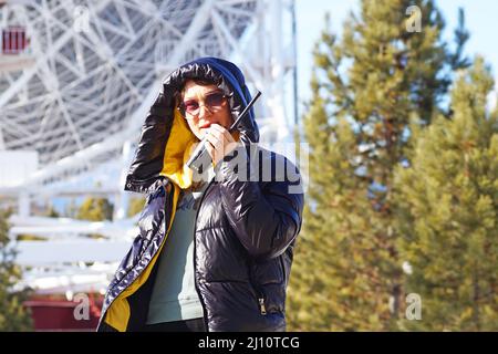 A woman talking on a walkie-talkie Stock Photo