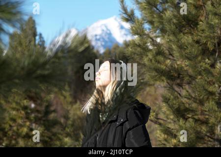 Teenage girl on the background of mountains on a sunny day Stock Photo