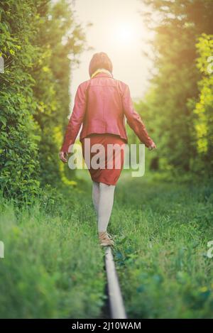 Girl balancing on a railroad track. Stock Photo