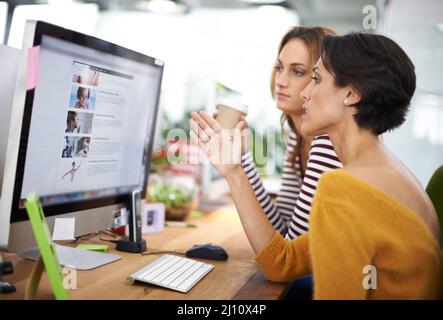 This design looks promising.... Cropped view of two young designers working on computers. Stock Photo