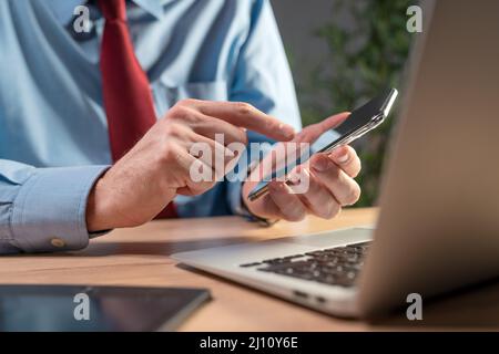 Businessman using smartphone and laptop computer, selective focus Stock Photo