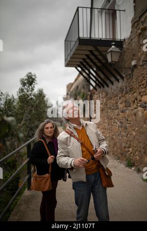 A couple, man and woman, 60 and 70 years old, with gray hair, are doing rural tourism and visiting a small village, Malejan, in the province of Zarago Stock Photo