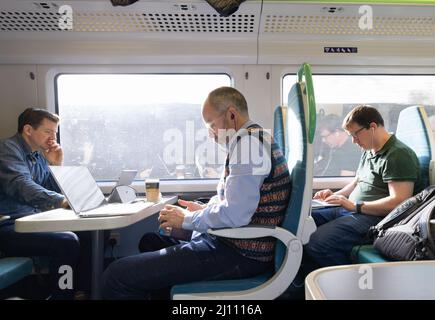 Train passengers UK; Railway commuters working with computers on the train, UK Stock Photo