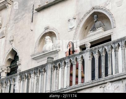 Stylish young woman standing on the balcony of a beautiful old building in the city of Koper Stock Photo