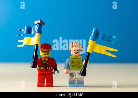 Lego little men with flags of Ukraine. A minifigure toy man holding a blue flag. Support of the Ukrainian people. Ukraine, Kyiv - March 20, 2022. Stock Photo