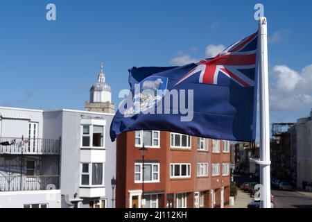 Flag of the Falkland Islands fluttering in the breeze in Portsmouth next to the square tower. Stock Photo
