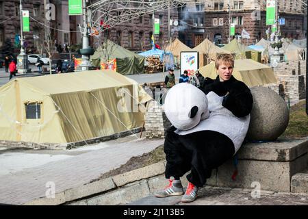 Kyiv, Ukraine - A young man dressed as panda bear is relaxing by tents in the city center. Ukrainian war with Russia. High-quality photo Stock Photo