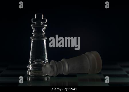 Fallen chess king as a metaphor for fall from power black background copy space Stock Photo