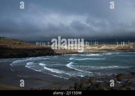 Windfarm turbines seen across the bay of Playa Grande on the east coast at Poris de Abona, Tenerife, Canary Islands, Spain Stock Photo