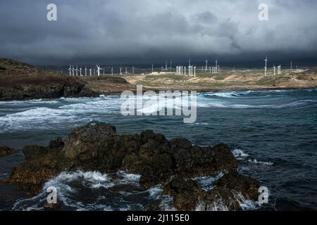 Windfarm turbines seen across the bay of Playa Grande on the east coast at Poris de Abona, Tenerife, Canary Islands, Spain Stock Photo