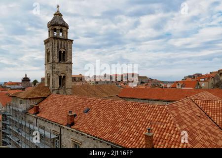 Saint Dominic Church Bell Tower and red rooftop against blue sky with clouds in the old town of Dubrovnik, Croatia. Stock Photo