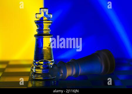 Fallen chess king as a metaphor for fall from power ukrainian flag background copy space Stock Photo