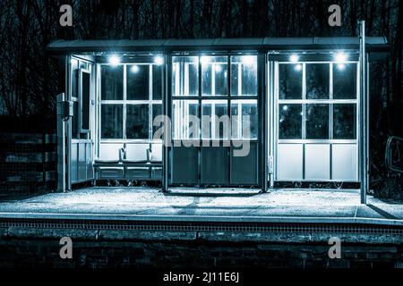 Train, railway station platform shelter at night. UK Stock Photo