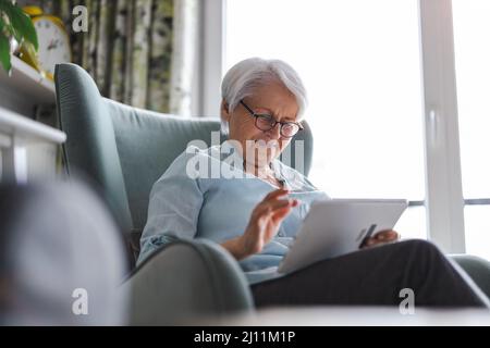 Senior woman using a digital tablet at home Stock Photo