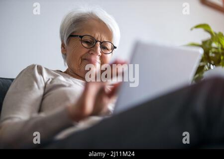 Senior woman using a digital tablet at home Stock Photo