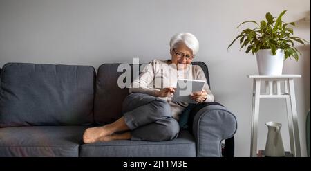 Senior woman using a digital tablet at home Stock Photo