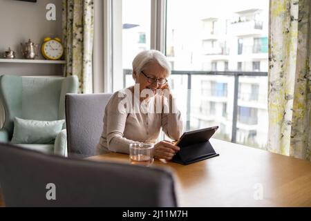 Senior woman using a digital tablet at home Stock Photo