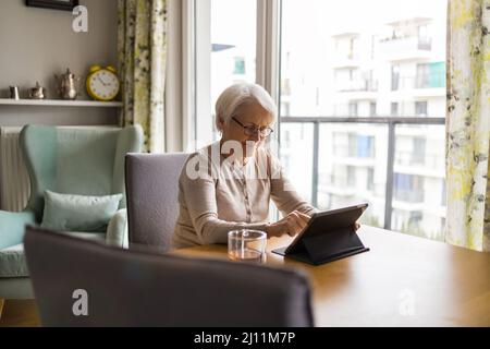 Senior woman using a digital tablet at home Stock Photo