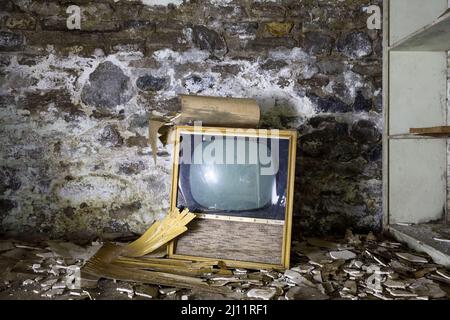 A retro television in side the basement of an abandoned building. Stock Photo