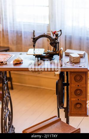 Top view of Willcox & Gibbs S.M.Co Chain Stitch Sewing Machine on sewing table at the Riordan Mansion in Flagstaff, Arizona, U.S.A. Stock Photo