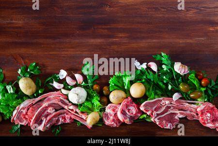 Raw mutton and vegetables assortment on natural wooden background Stock Photo