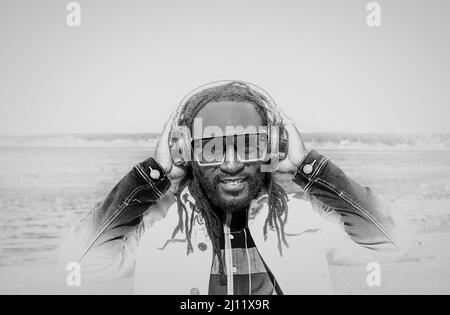 Handsome attractive young african american man with dreadlocks listening music outdoor. White and Black Photo. Street photo. White Rock BC, Canada-Mar Stock Photo