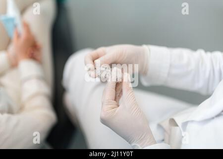 Professional dentist showing and explaining to a client how the invisalign works Stock Photo