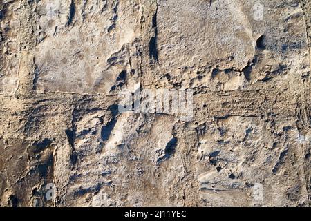 Surface of a light-colored wall that is made up of rustic tiles in irregular shapes Stock Photo