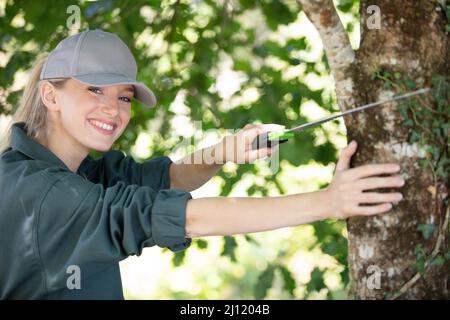 woman gardener using saw for sawing tree branches Stock Photo