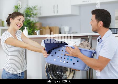 happy couple doing laundry together Stock Photo
