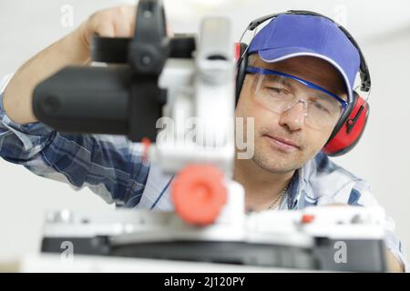 close view of workman using circular saw Stock Photo
