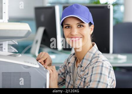 young female technician fixing a printer Stock Photo