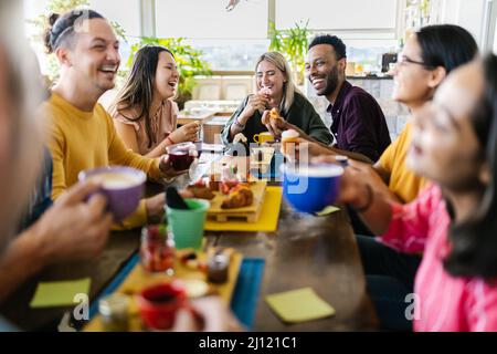 Multiracial people gathering together while having breakfast on rooftop cafe Stock Photo