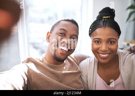 Smile for the camera. Portrait of a young couple taking selfies together at home. Stock Photo