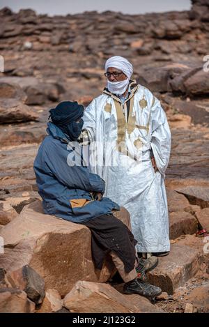 Two Mauritanian men with turbans talking in a rocky landscape, Asrar Region, Mauritania Stock Photo