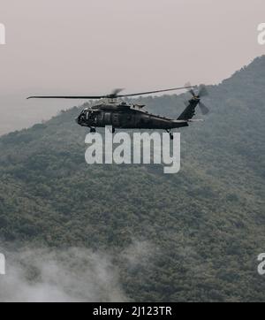 A UH-60 Black Hawk helicopter crew, assigned to 2nd Battalion, 25th Combat Aviation Brigade, fly as part of aerial formation training during Hanuman Guardian 22, Lop Buri, Kingdom of Thailand, Mar. 19, 2022. Working together, the U.S. Army and the Royal Thai Army conduct multinational, combined task force events that are vital to maintaining the readiness and interoperability of security forces across the region. (U.S. Army photo by Staff Sgt. Timothy Hamlin) Stock Photo