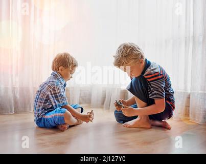 Let the games begin. Shot of two little boys playing together at home. Stock Photo