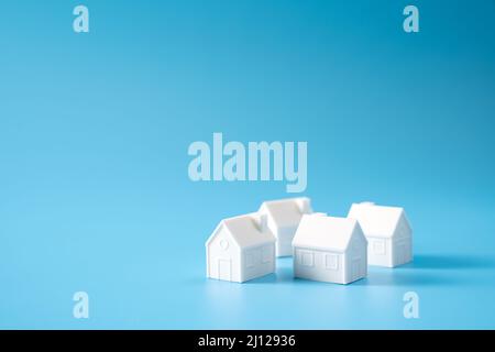 Miniature 3D printed model house on blue background Stock Photo