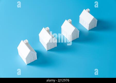 Miniature 3D printed model house on blue background Stock Photo