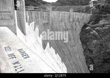 Danger signage at the massive concrete wall of the Hoover Dam, USA Stock Photo