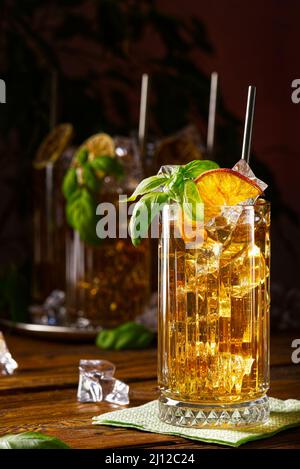 Glass of long island ice tea cocktail decorated with mint. Cuba Libre low key Stock Photo