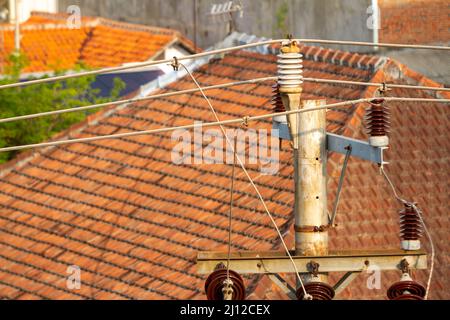 Electrical installation network with concrete poles on the streets side by side with people's houses in Indonesia, between energy needs and danger Stock Photo