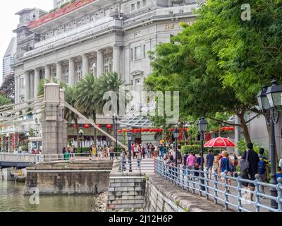 The Cavenagh Bridge and the Fullerton Hotel at the end of the Boat Quay walkway - Singapore Stock Photo