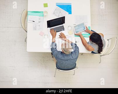 Managing their meeting with modern technology. Shot of a two colleagues having a meeting in a modern office. Stock Photo